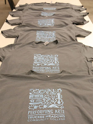 Gray t-shirts in a row on a table.