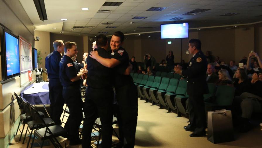 Cadets hugging at the fire academy graduation.