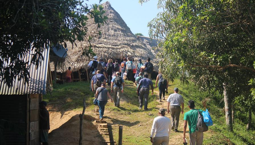 group of volunteers walking up to a hut