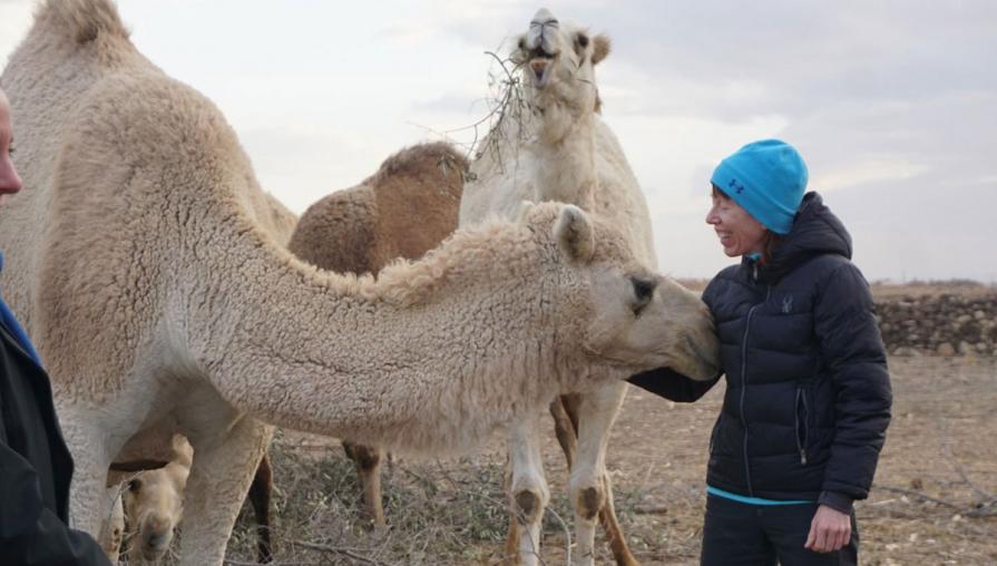 Namie standing next to two camels.