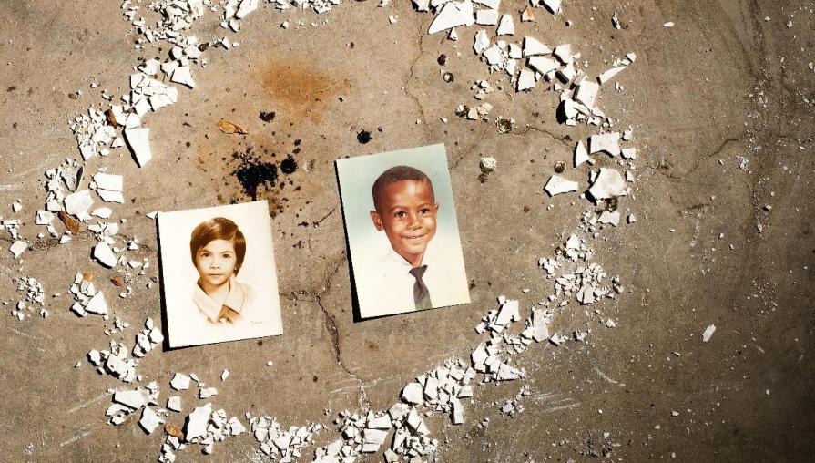 Two photos of young boys rest on the concrete, surrounded by shattered ceramic pieces. Origins, by Jordyn Owens.