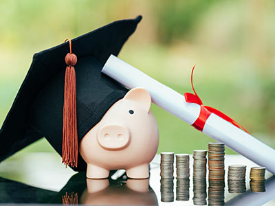 Piggy bank with diploma and cap