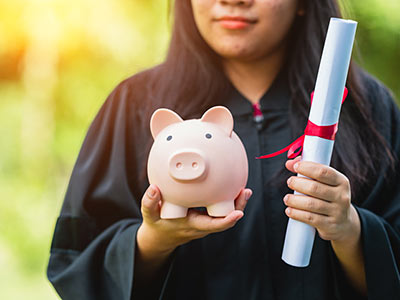 Person holding piggy bank and diploma