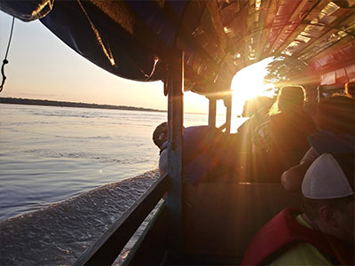 Boat traveling down the Amazon at sunset.