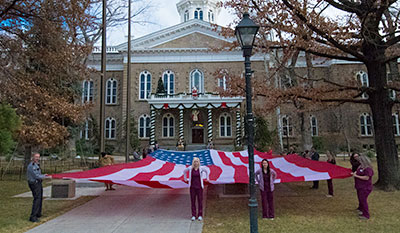 Dental Hygiene students help a veteran display an American flag.