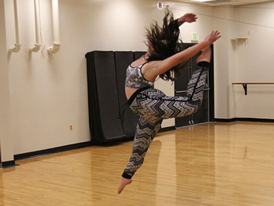 A dancer leaping in a studio.