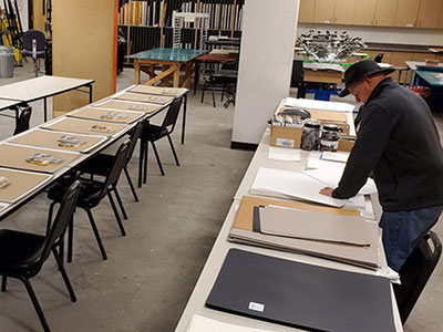 Instructor assembles drawing kits for students.