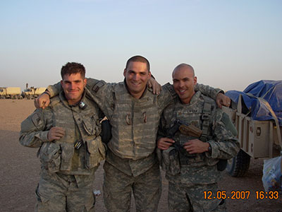 Three soldiers in uniform pose for a photo.