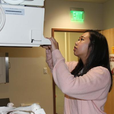 Rad tech student getting firsthand experience with an x-ray machine.