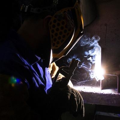A welding student lights their torch in one of TMCC's workshops.