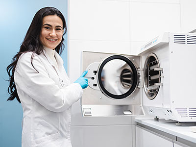 A sterile processing technician cleans her instruments in an autoclave.