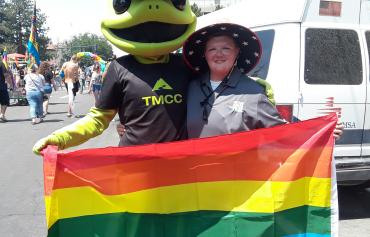 Mascot holding pride flag with student