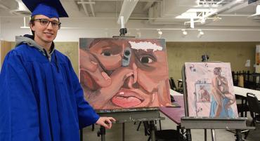 Graduate Tyler Sullivan poses with his art.