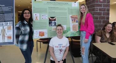 Students from an Anatomy and Physiology class stand by their research on skin at the Diversity Fair.