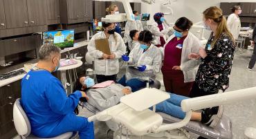 TMCC Dental Hygiene and Dental Assisting students observe a dentist working with a patient.