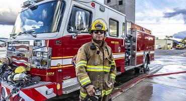 Fire Academy Commander Nick Corona stands proudly beside his firetruck.