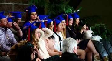 Nursing program graduates sit happily at their Pinning Ceremony.