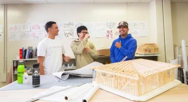 Architecture students, a possible Career and Technical Education track, enjoy classroom instruction beside blueprints and a building model.