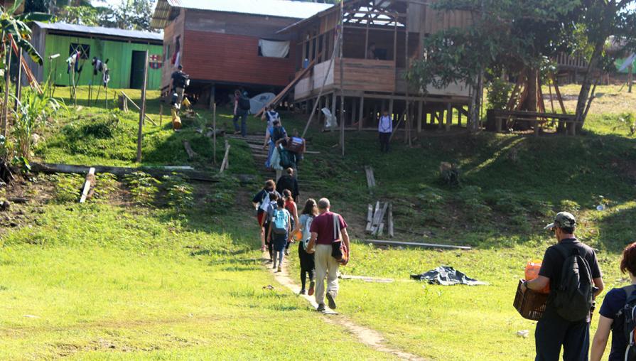 volunteers walking towards a building in the village