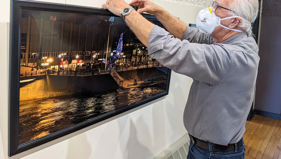 Artist hanging a photo in a gallery.