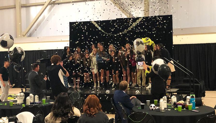 Mighty Lizards Women's Soccer team accepts first-ever Silver State Champion trophy.