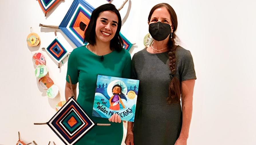 Juliana Urtubey with Professor Micaela Rubalcava in front of a sustainability art display.