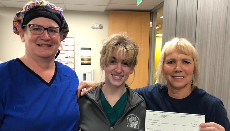 Julie McMahon, Amanda King, and Terri Braunworth (Palomino Valley Pet Rescue) hold up donation check.