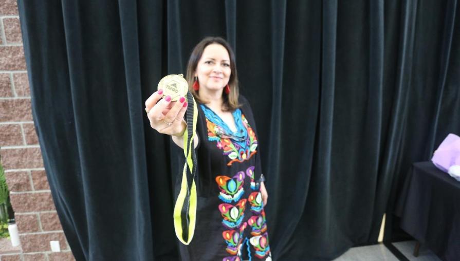 Juana Reynoza-Gomez holds up the Unity Graduation medallion.