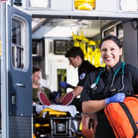 Paramedic standing behind an ambulance