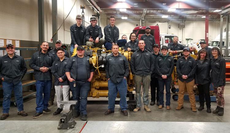 Diesel Program instructors and students gathered around mechanical equipment.