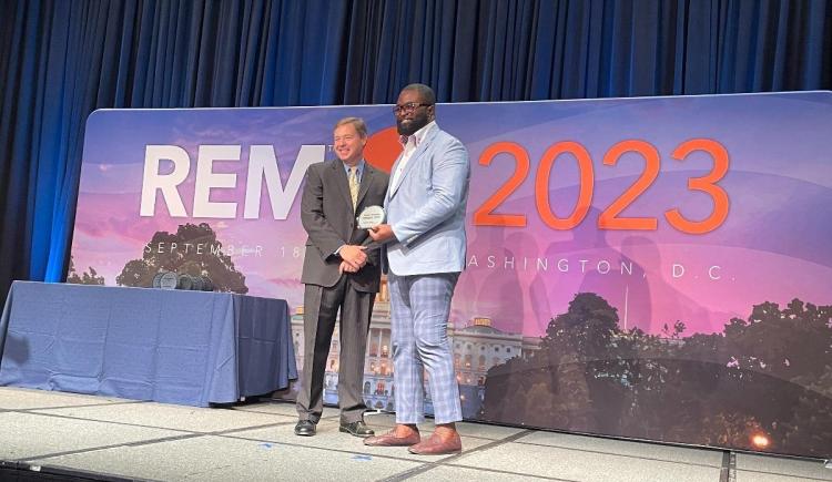 Ayodele Akinola accepts the 2023 Green Power Leadership Award for TMCC at the Renewable Energy Markets Conference.