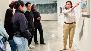 Education staff at Nevada Museum of Art point out attributes of Ben Aleck's paintings to TRIO students.