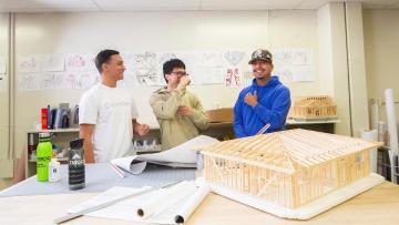 Architecture students, a possible Career and Technical Education track, enjoy classroom instruction beside blueprints and a building model.