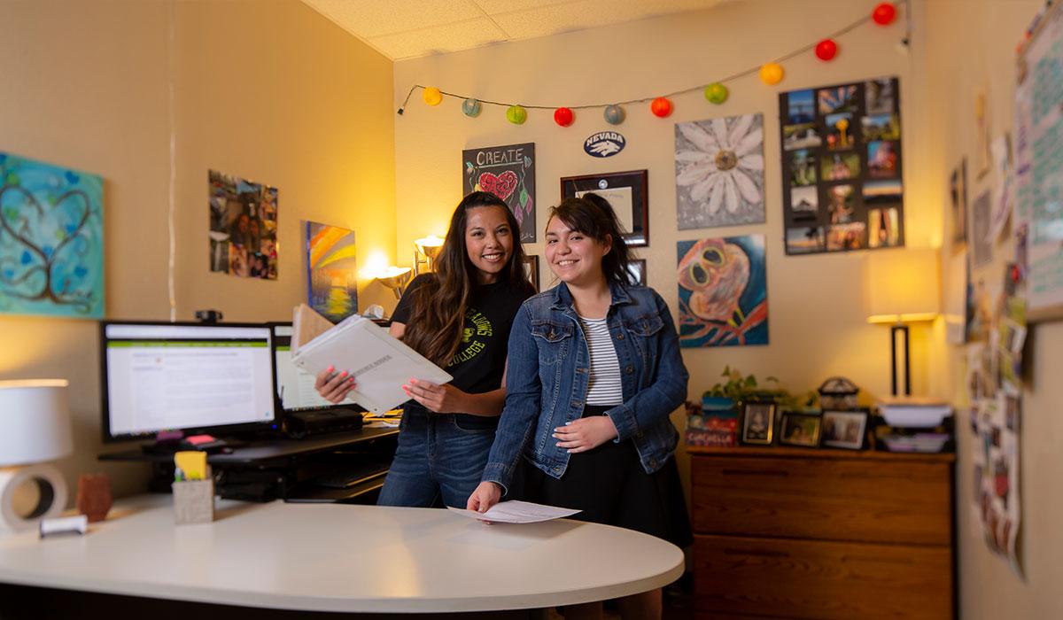 Two students smiling in an office.