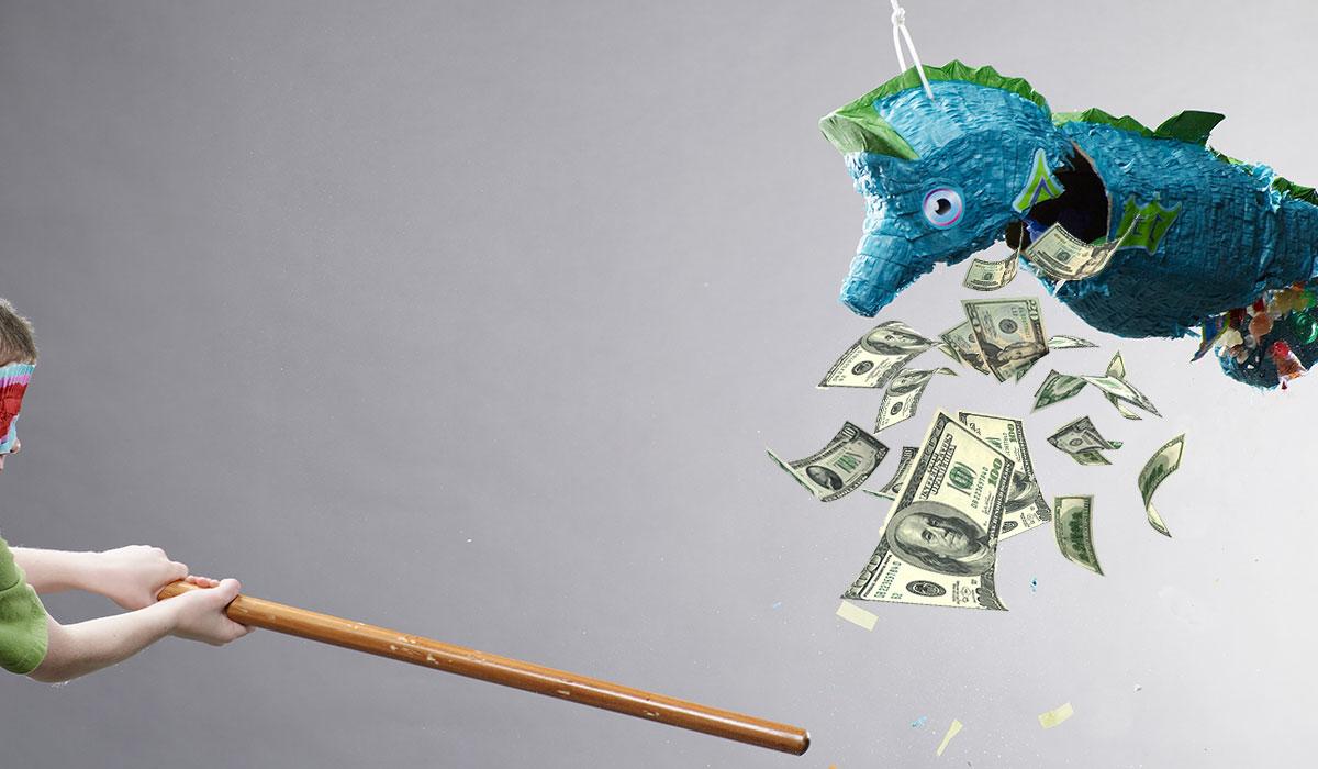 A person hitting a piñata with a stick. Money is falling out of the piñata.