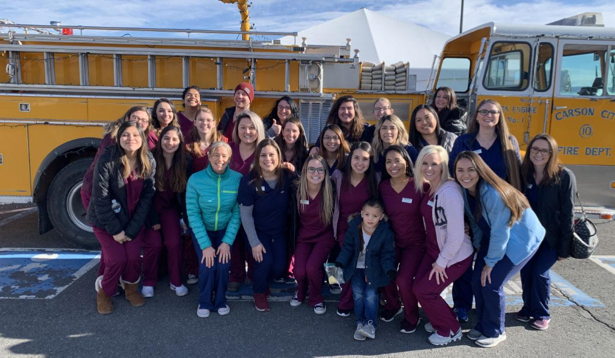 Dental Hygiene students pose for a photo in front of a fire engine.