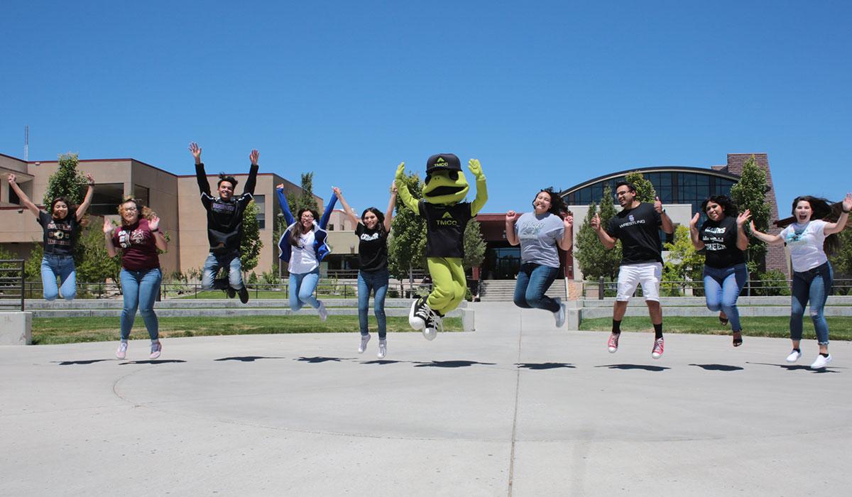 TMCC students and mascot jumping in the air.