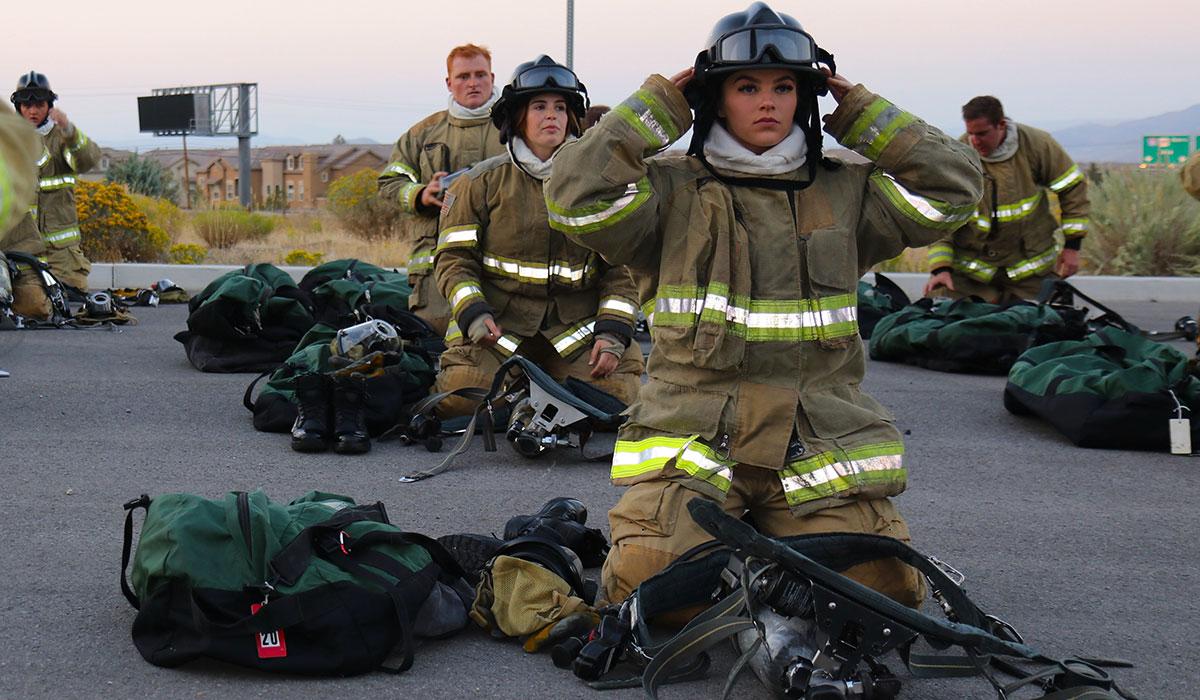 Fire cadets don their gear outdoors.