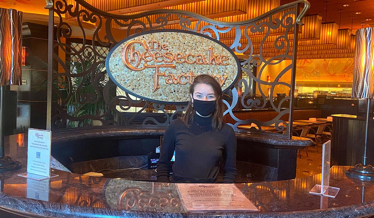 TMCC Hospitality and Tourism graduate Emily Lorge working as a hostess at The Cheesecake Factory
