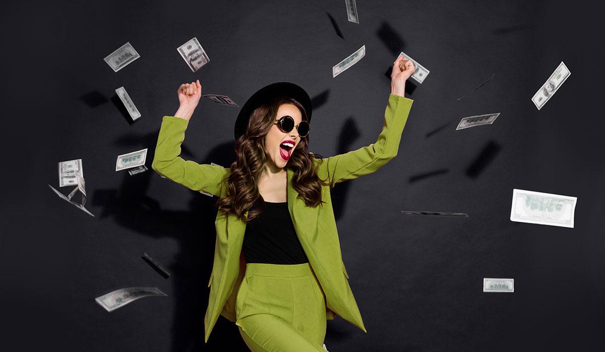 Woman dancing in a green suit for Financial Aid Awareness Month.