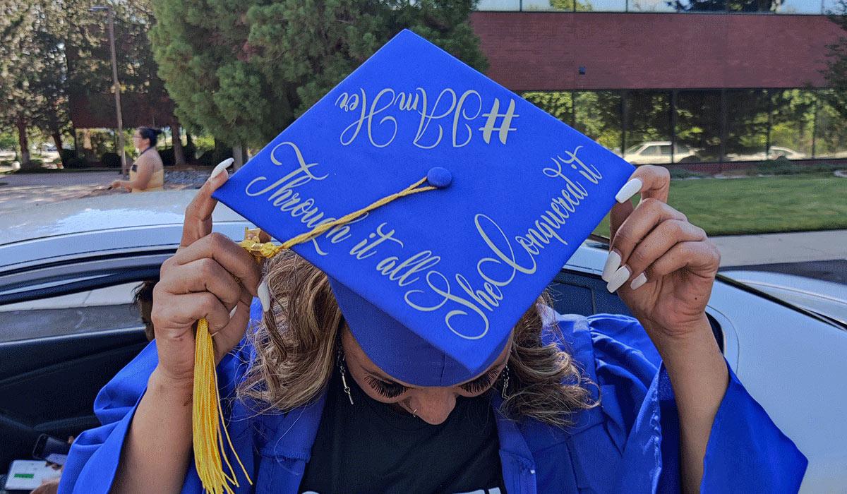 Graduate displays decorated cap at HSE graduation ceremony.
