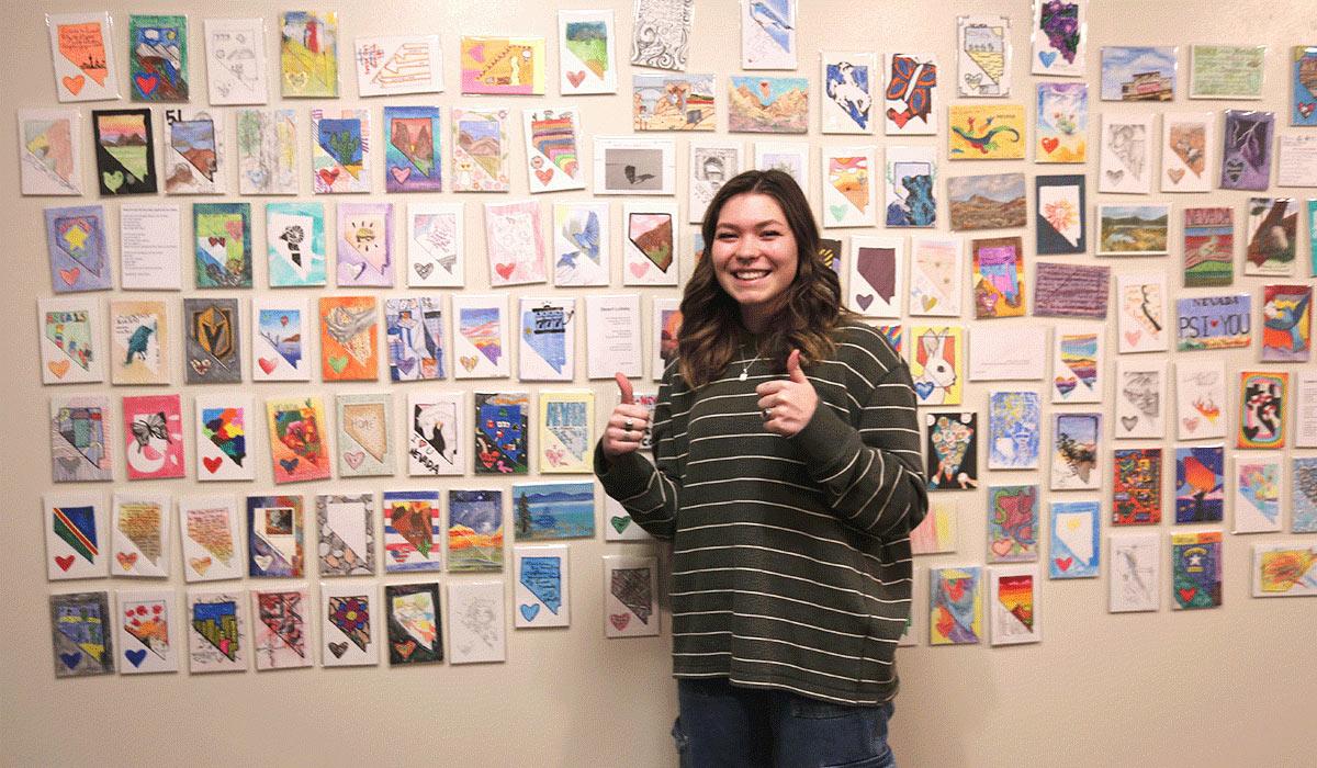 TMCC Student Jessica Green stands next to her work featured in the Nevada P.S. I Love You Exhibition.