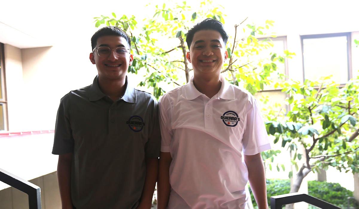Joshua and Jeziel Guerra standing beside each other on stairwell of Red Mountain Building.