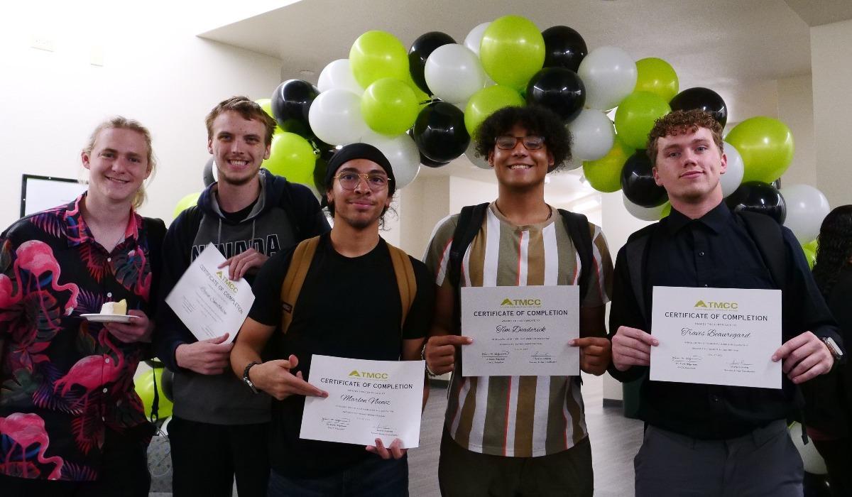 Summer Bridge students are standing proudly with their certificates of completion and celebratory cake.