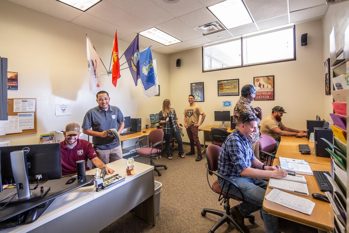 A group of student veterans studies and collaborates in the Veterans Resource Center computer lab.