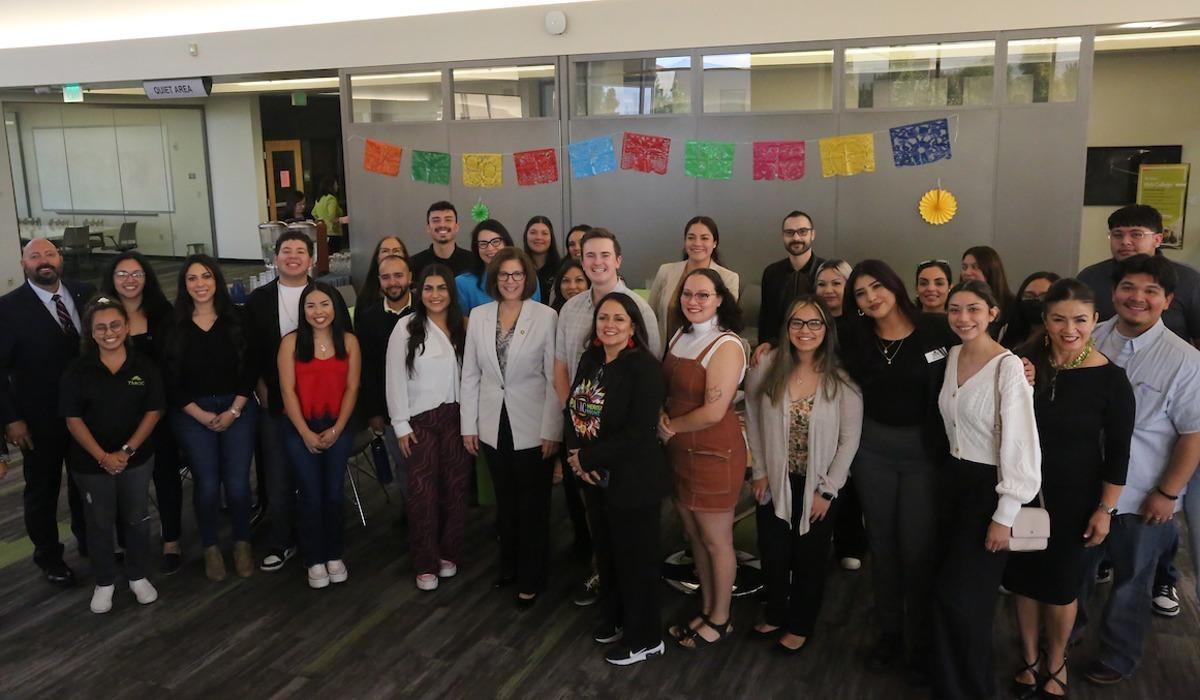 Senator Catherine Cortez-Masto stands smiling beside students and leadership on the second floor of the Elizabeth Sturm Library for a photo.
