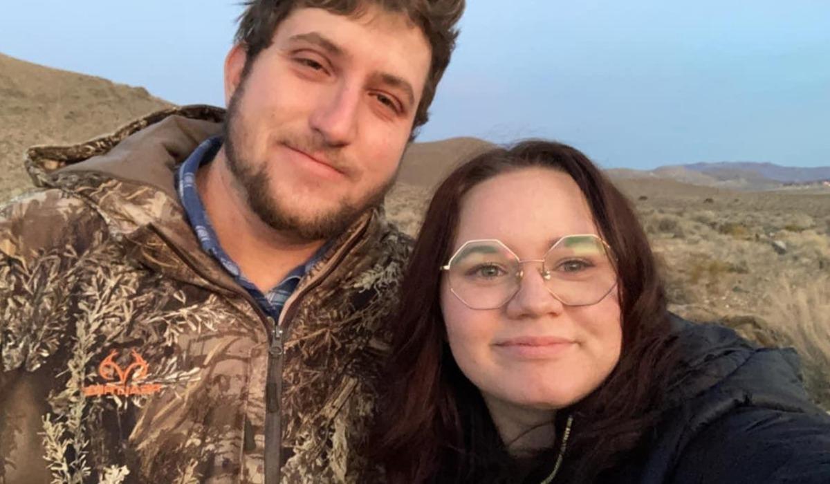 Shelby Rosebush and her fiancé, Douglas, pose for a picture together surrounded by desert landscape.