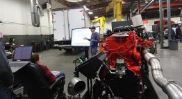 Students in an automotive lab using a large touch screen panel.