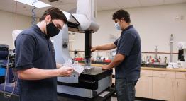 Students work on a machine in a technology lab.