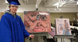 Graduate Tyler Sullivan poses with his art.